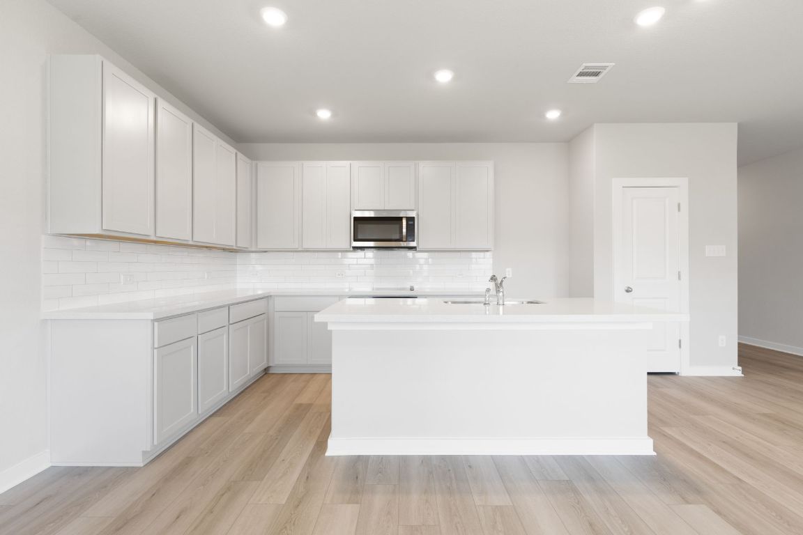 13617 Gray Landing Drive Elgin, TX 78621 - Photo 5 of 29 a kitchen with kitchen island sink stove and cabinets