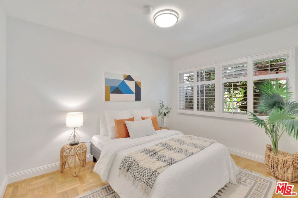 5372 Village Los Angeles, CA 90016 - Photo 15 of 28 a bedroom with bed and a potted plant