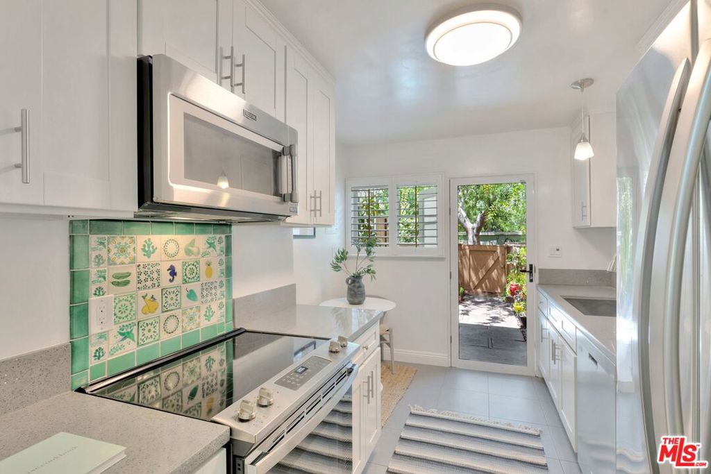 5372 Village Los Angeles, CA 90016 - Photo 7 of 28 a kitchen with stainless steel appliances granite countertop a stove a sink and a microwave