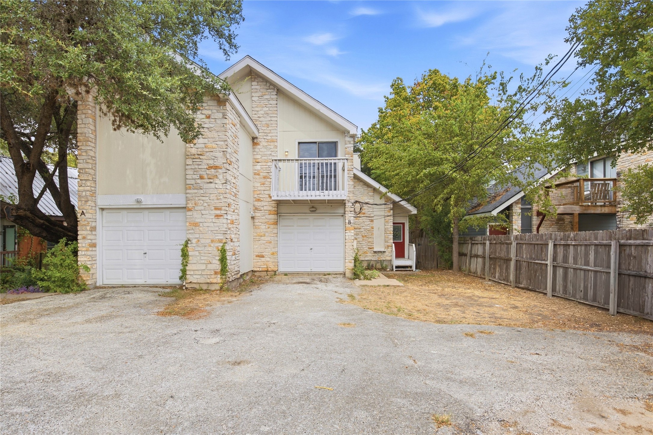 2500 Jones Road, Unit B Austin, TX 78745 - Photo 12 of 37 Natural stone accents and dual garages define this multi-level exterior nestled among mature trees.