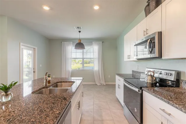 a kitchen with stainless steel appliances granite countertop a sink stove and cabinets