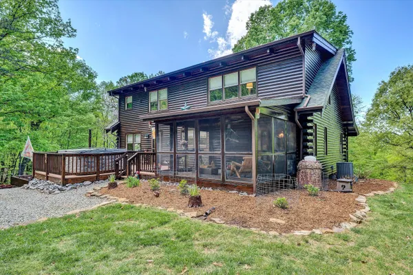 a view of a house with a yard chairs and table in a patio