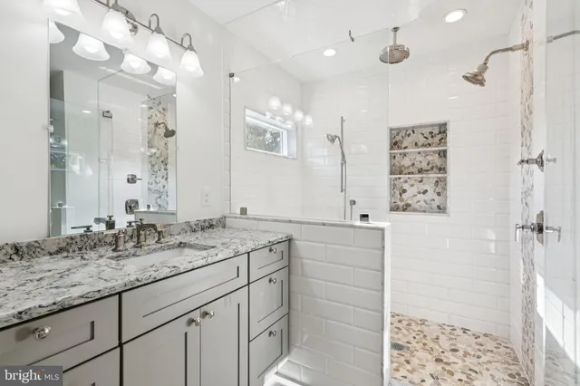 a bathroom with a sink vanity granite and a shower