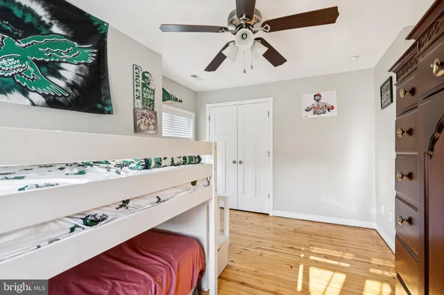 a bedroom with a bed and a chandelier fan