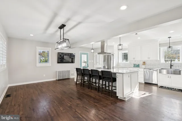 a large white kitchen with lots of counter space dining table and chairs