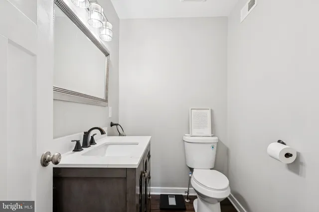 a bathroom with a sink a toilet and a mirror