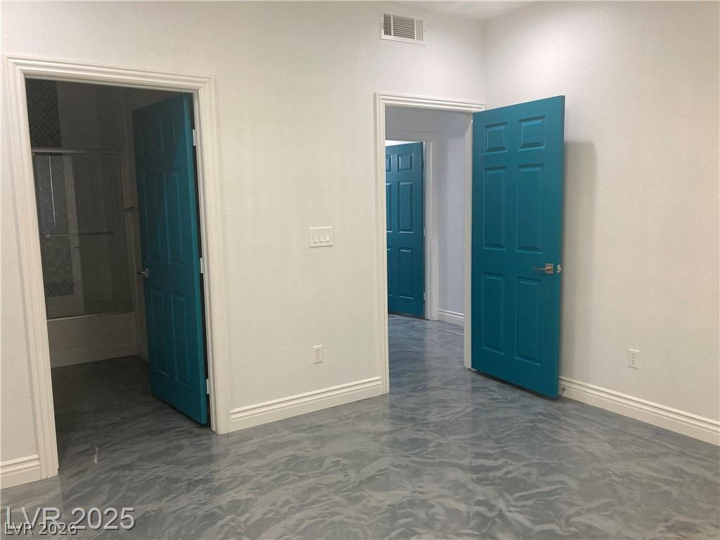 9050 West Warm Springs Road, Unit 1027 Las Vegas, NV 89148 - Photo 13 of 44 Boldly painted doors open to reveal an interior space featuring sleek, reflective flooring.