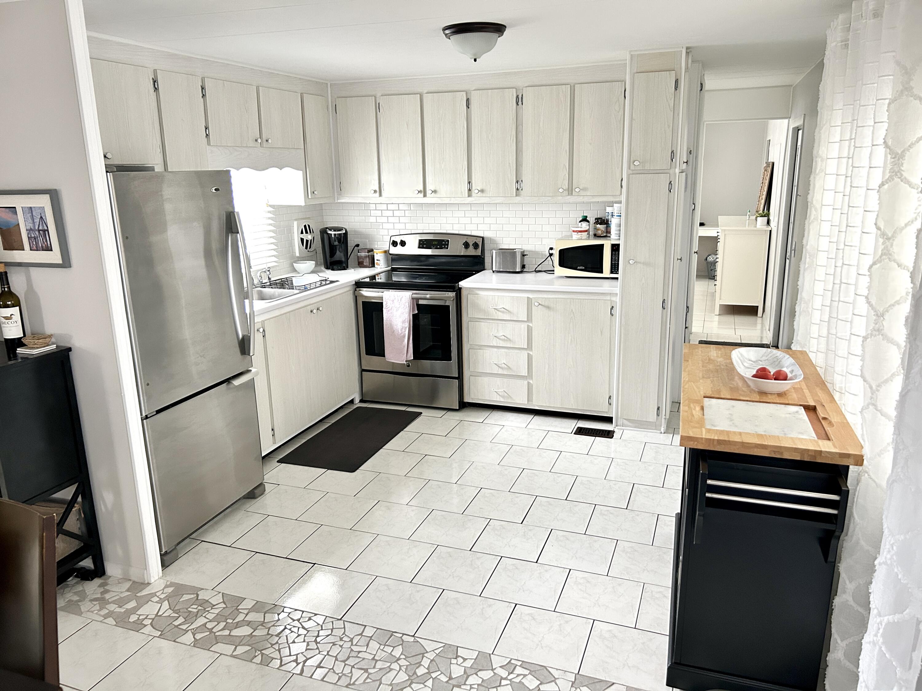 3240 State Street Hollywood, FL 33021 - Photo 9 of 29 a kitchen with a sink a refrigerator and cabinets