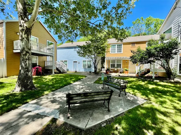 a view of a house with backyard sitting area and a tree