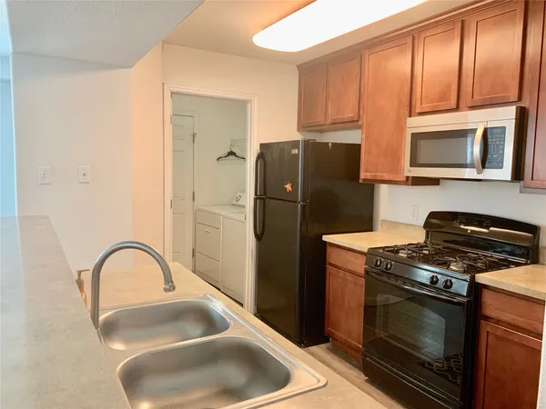 a kitchen with stainless steel appliances granite countertop a stove a refrigerator and a sink