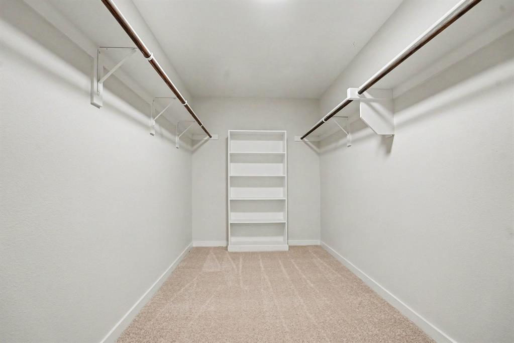 2606 Middleton Road Glenn Heights, TX 75154 - Photo 12 of 18 Master- Neutral-toned carpeting, built-in shelving unit, and dual clothing rods