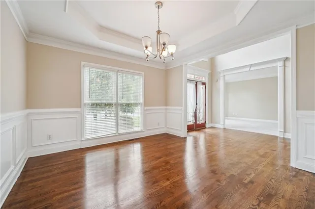 a view of an empty room with wooden floor fireplace and a window