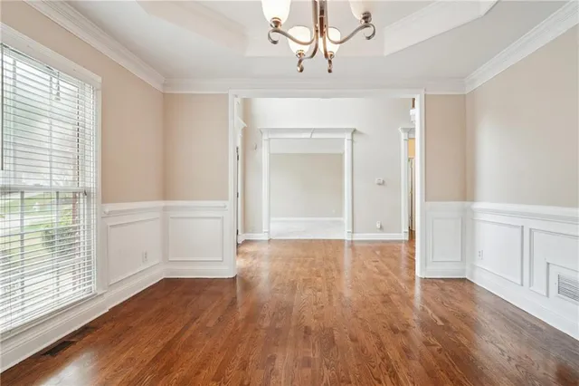 a view of a hallway with wooden floor and a kitchen
