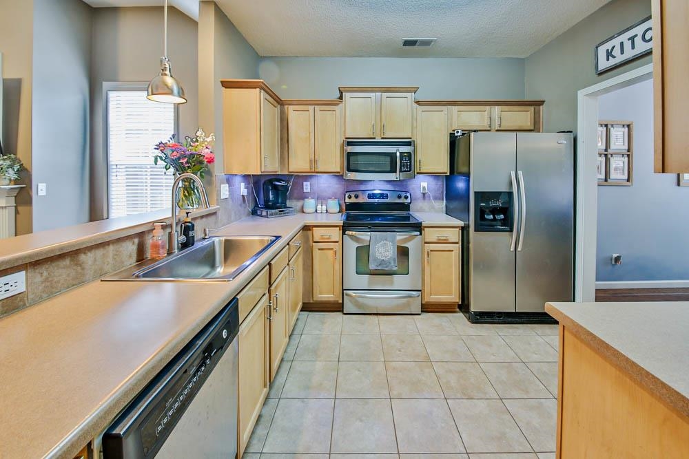 4964 Shaws Ridge Trail Arlington, TN 38002 - Photo 3 of 20 a kitchen with stainless steel appliances granite countertop a sink stove refrigerator and cabinets