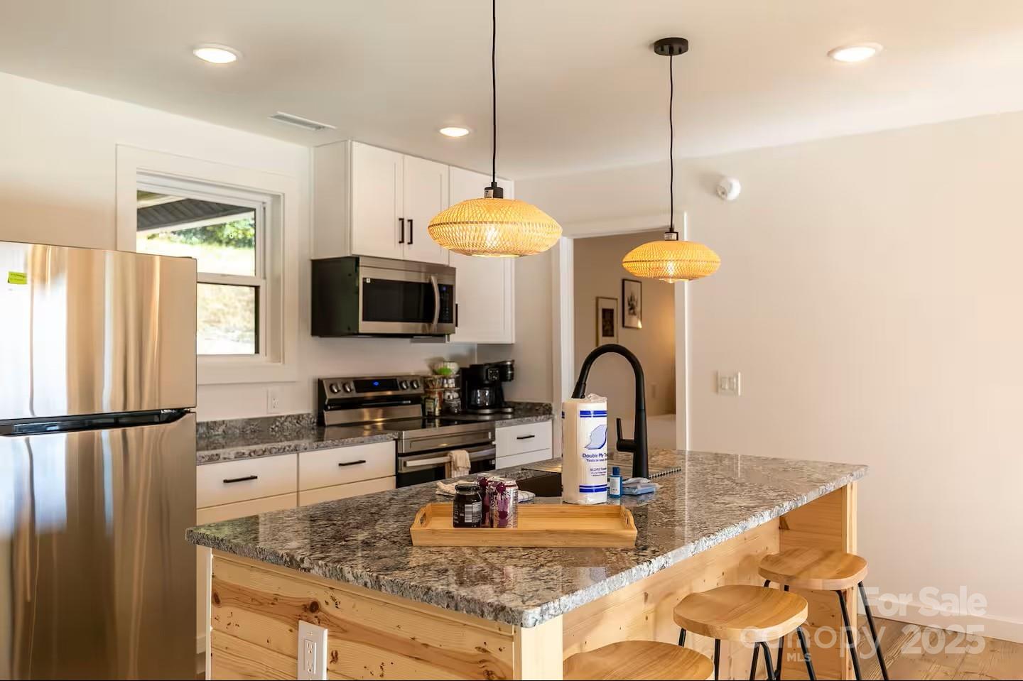 4612 Shulls Mill Road Blowing Rock, NC 28605 - Photo 11 of 35 a kitchen with stainless steel appliances granite countertop a sink a stove and a wooden floor