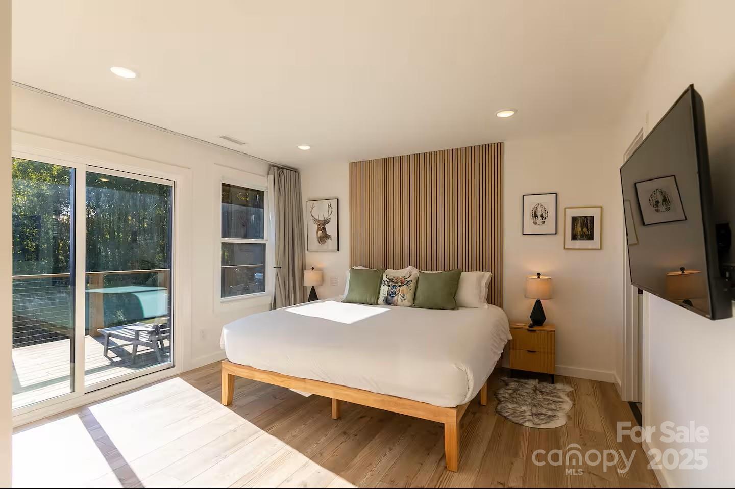 4612 Shulls Mill Road Blowing Rock, NC 28605 - Photo 16 of 35 a bedroom with a bed and a flat tv screen next to a window