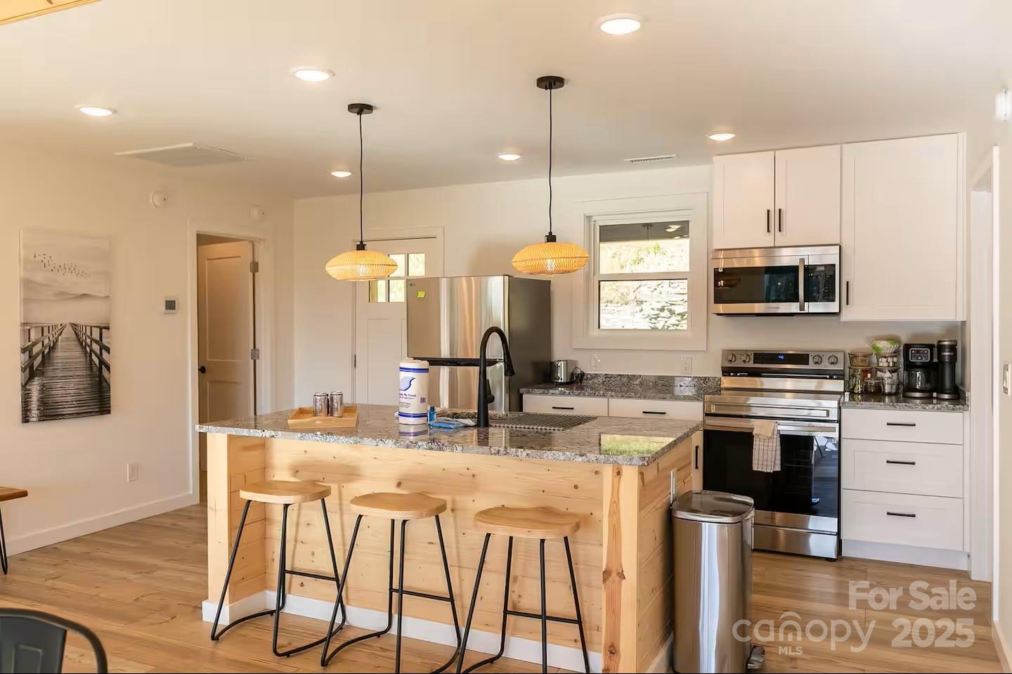 4612 Shulls Mill Road Blowing Rock, NC 28605 - Photo 9 of 35 a kitchen with stainless steel appliances kitchen island granite countertop a stove a sink and a microwave