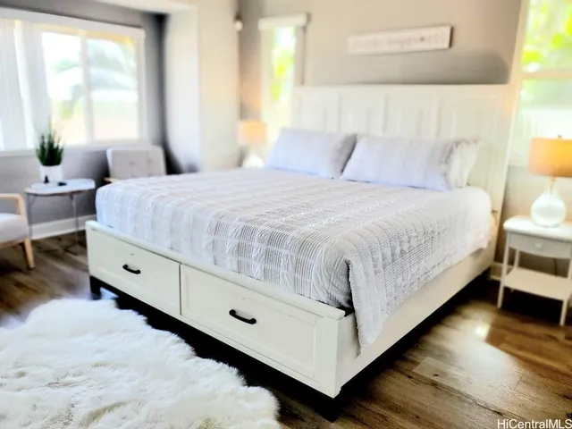 a large bed sitting in a bedroom next to a window