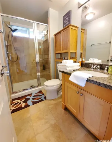 a bathroom with a granite countertop sink toilet and shower