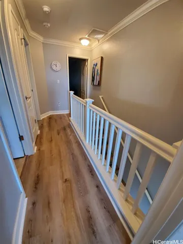 a view of a hallway with wooden floor and staircase