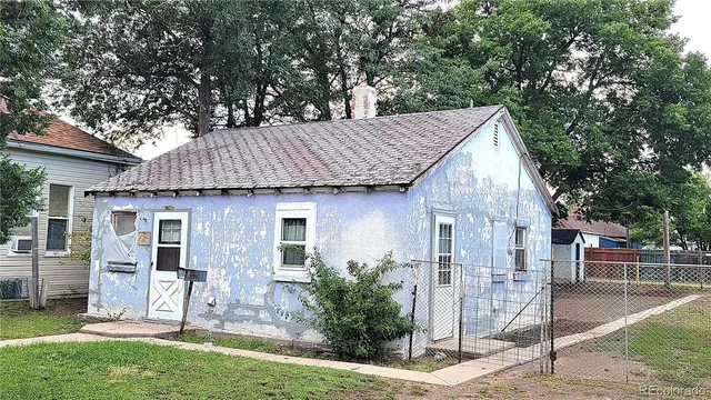 a view of a house with backyard and a tree
