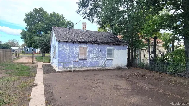 a view of a barn house with a big yard and large tree