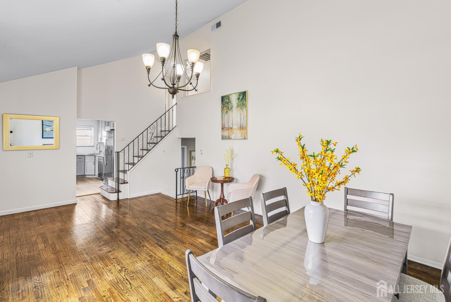 23 Carmello Drive Edison, NJ 08817 - Photo 3 of 28 a dining room with wooden floor a chandelier a wooden table and chairs