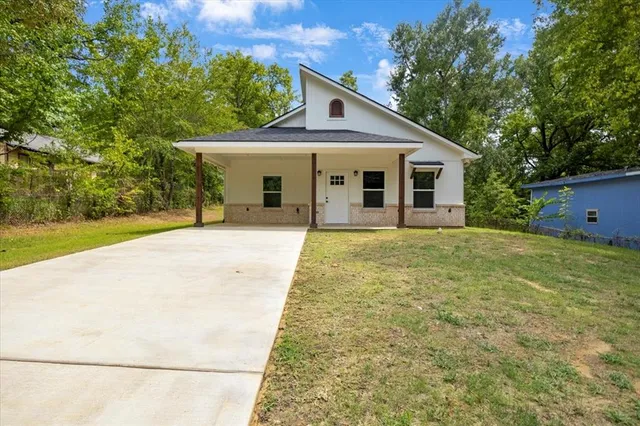 a front view of house with yard and trees around