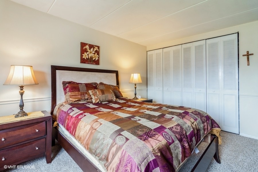 225 South Rohlwing Road, Unit 304 Palatine, IL 60074 - Photo 9 of 24 a bedroom with a bed and a lamp