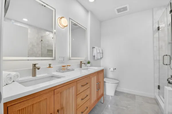 a bathroom with a sink a toilet and shower