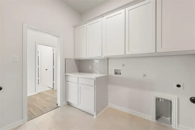 a view of cabinets and utility room with closet