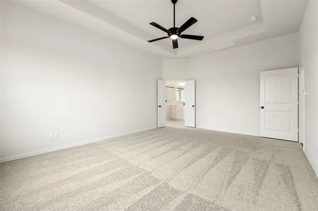 an empty room with ceiling fan and window