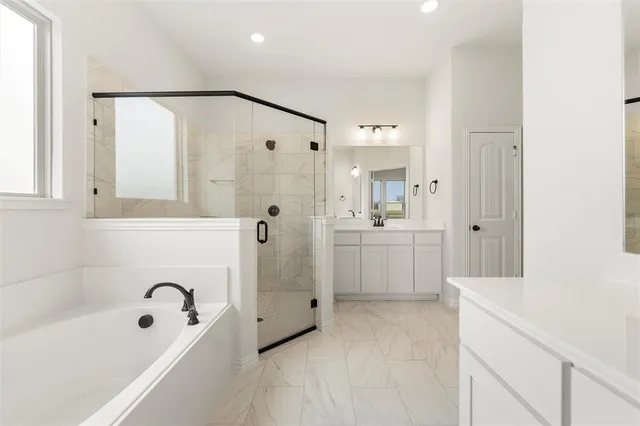 a bathroom with a bathtub a shower a sink and a mirror