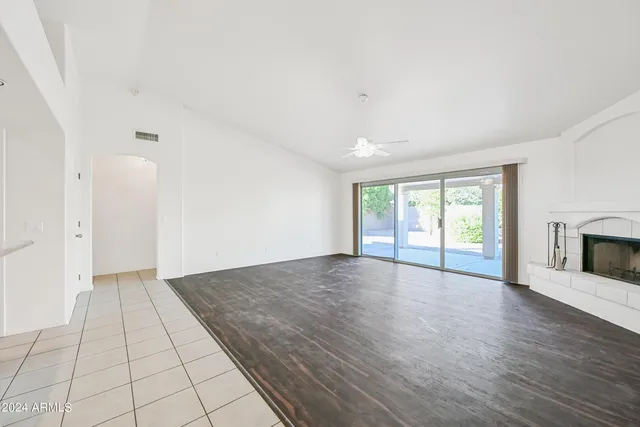an empty room with wooden floor and fireplace
