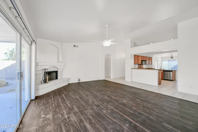 a view of a hallway with a kitchen and a fireplace