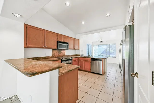 a kitchen with a stove a sink a microwave a counter top space and cabinets