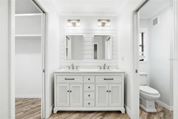 a bathroom with a granite countertop toilet a sink and a mirror