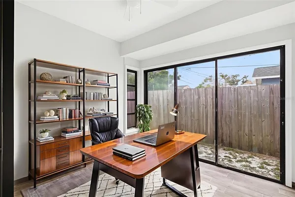 a view of a workspace with furniture and a window
