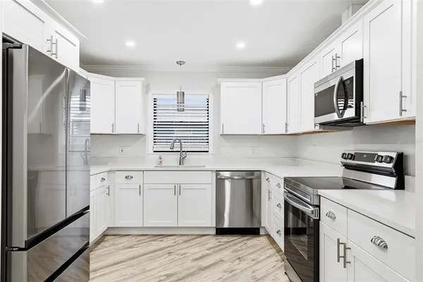 a kitchen with stainless steel appliances granite countertop a sink and a stove top oven