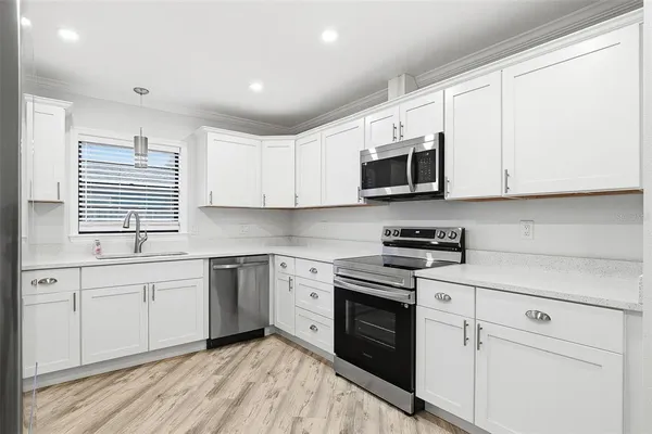 a kitchen with stainless steel appliances granite countertop white cabinets granite counter tops and a window