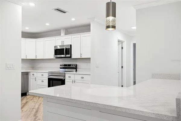 a kitchen with stainless steel appliances kitchen island granite countertop a stove a sink and a microwave