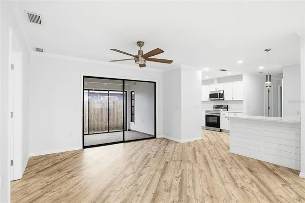 a view of a kitchen with wooden floor and a ceiling fan