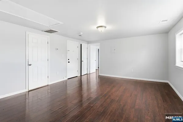 a view of an empty room with wooden floor