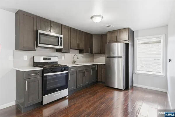 a kitchen with stainless steel appliances a refrigerator stove and microwave