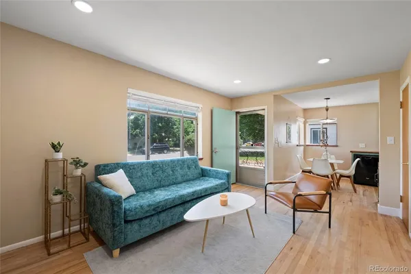 a living room with furniture and a wooden floor
