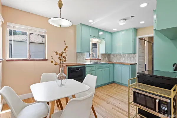a kitchen with stainless steel appliances kitchen island granite countertop a table and chairs