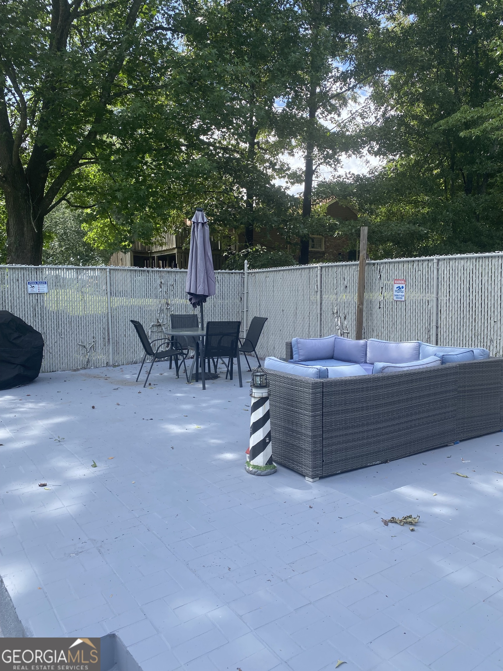 7383 Pleasant Hill Road Lithonia, GA 30058 - Photo 18 of 18 a view of a patio with table and chairs with wooden fence