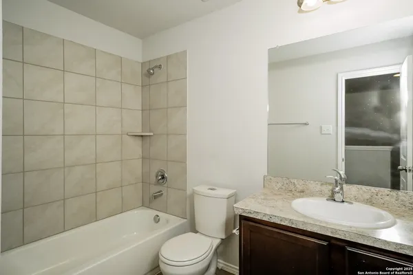 a bathroom with a granite countertop sink a toilet and bathtub