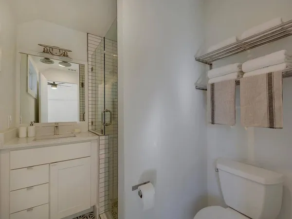 a bathroom with a granite countertop sink toilet and mirror