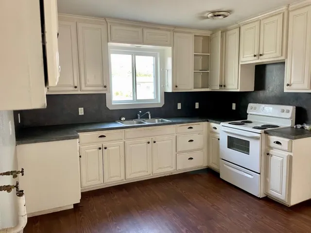 a kitchen with cabinets appliances a sink and a window